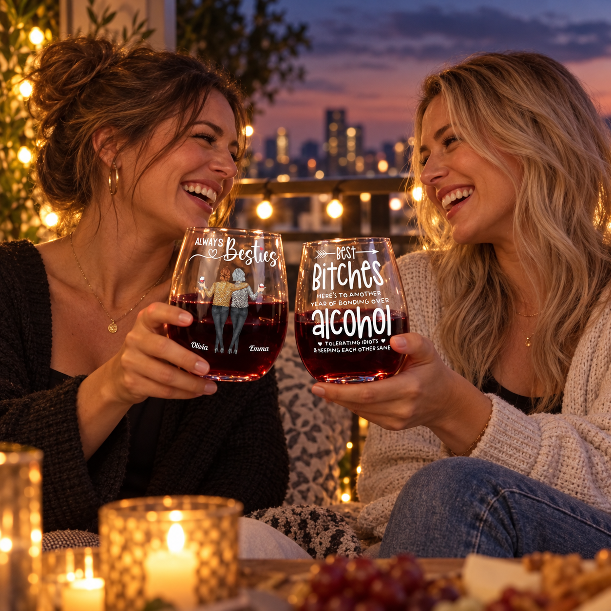 Two best friends clinking personalized stemless wine glasses on a balcony at dusk