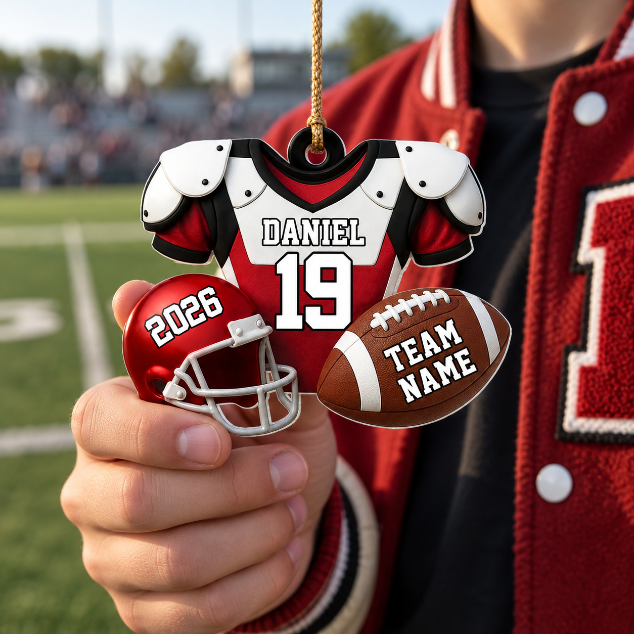 Teen football player holding a custom jersey ornament with name and number on the field