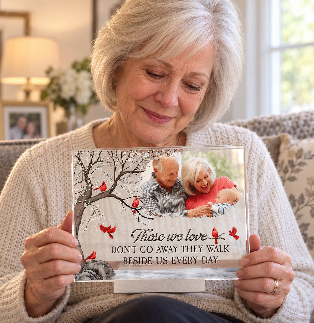 Older woman gently holding a personalized photo memorial acrylic plaque in her living room