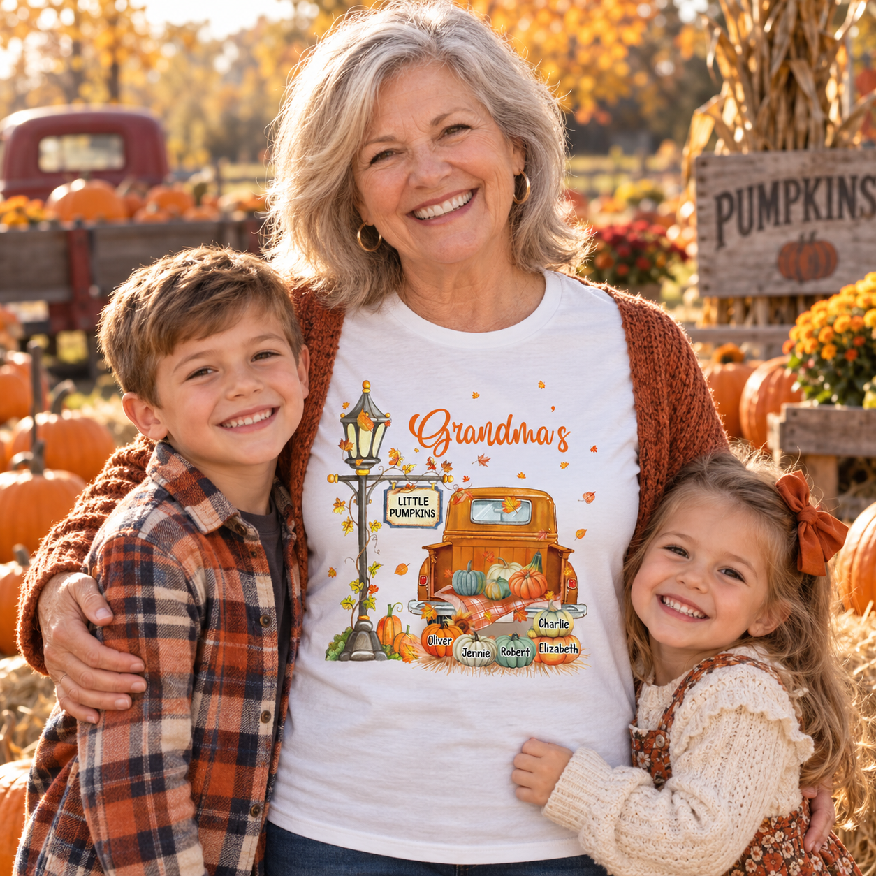 Grandma in a Grandma's Little Pumpkins truck t-shirt with two grandkids in a pumpkin patch