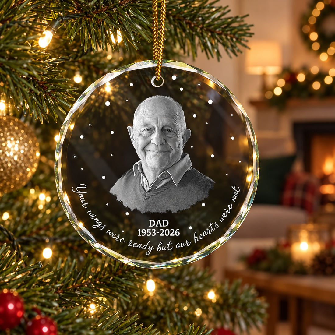Personalized memorial circle glass Christmas ornament hanging on a softly lit tree