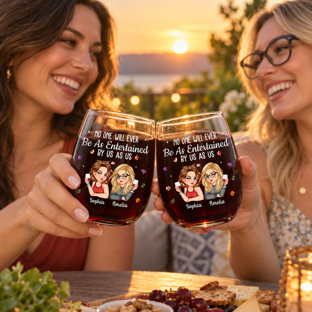 Two friends clinking personalized bestie stemless wine glasses on a patio at sunset