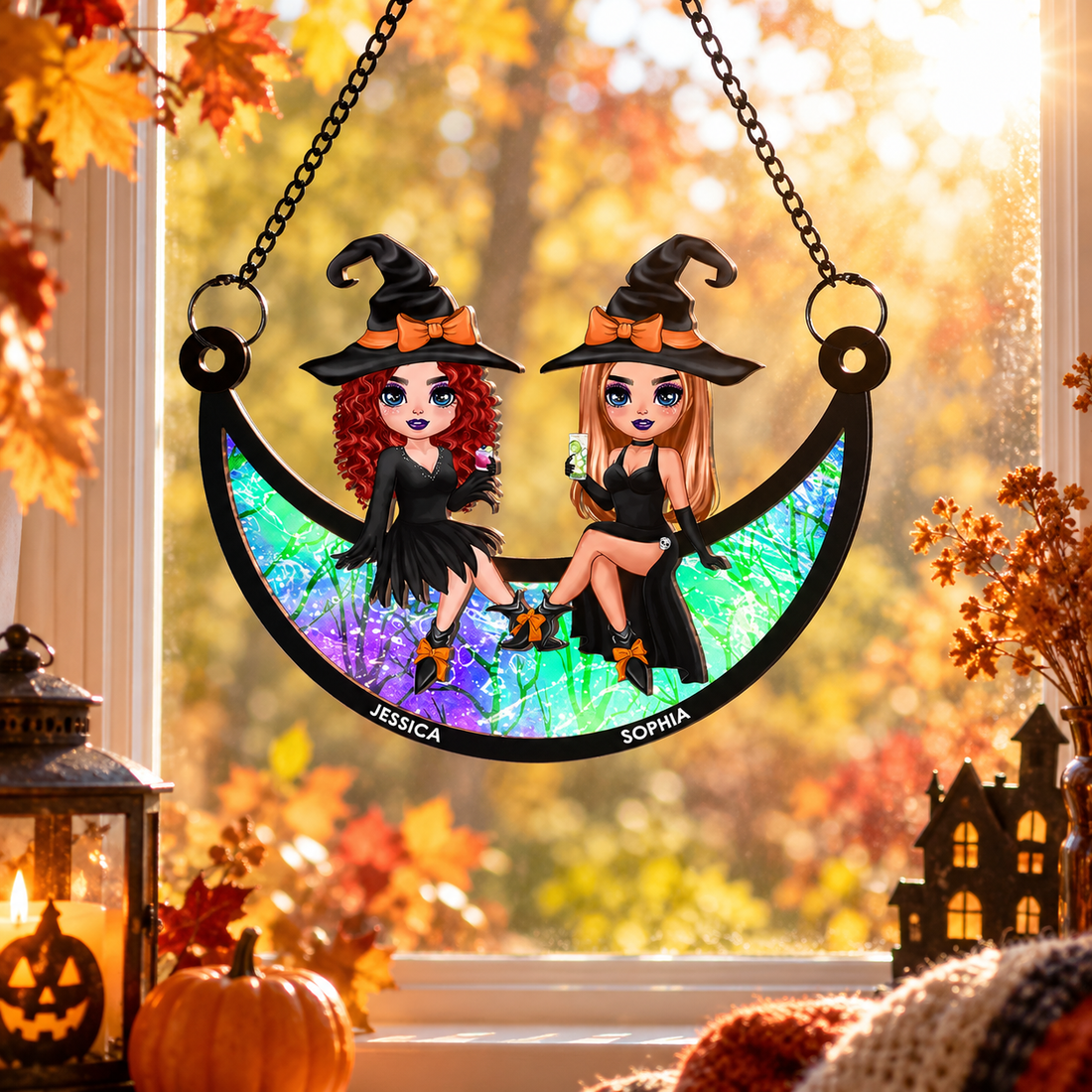Halloween witch besties on moon suncatcher hanging in a sunny window with autumn leaves