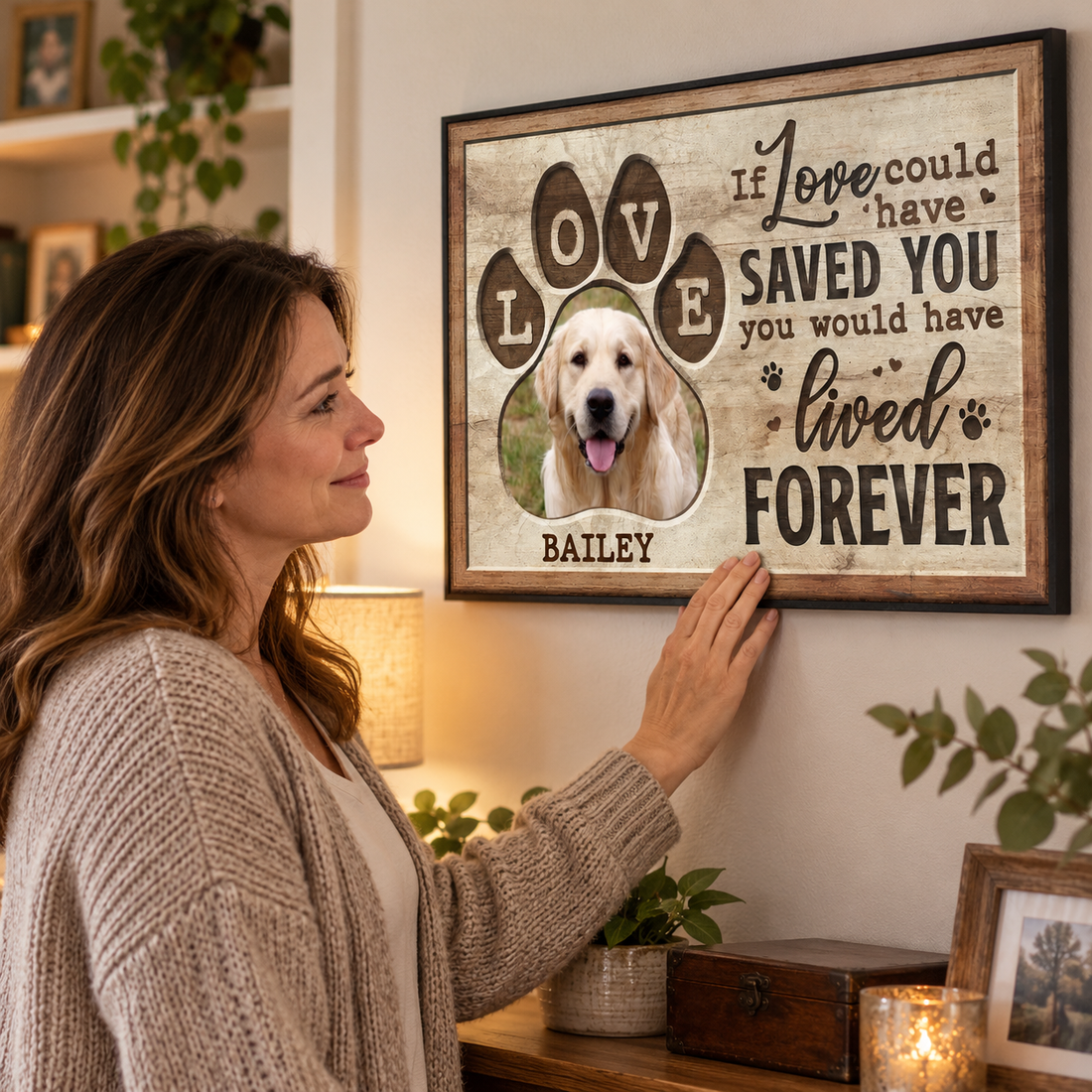 Woman gently touching a custom paw-print pet memorial canvas hung on her living room wall