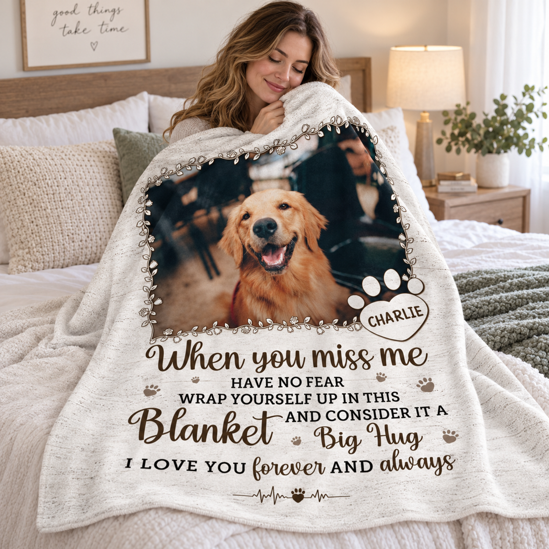 Woman wrapped in a custom pet memorial photo blanket on a bed in soft light