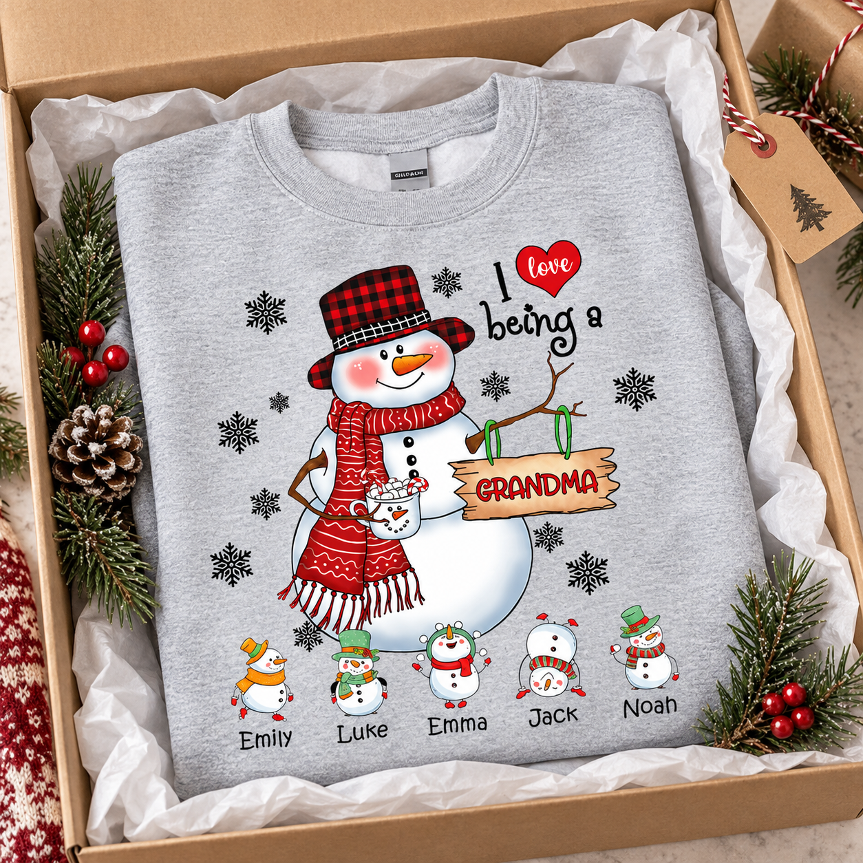 Gray snowman I love being a Grandma personalized Christmas sweatshirt folded in a gift box with pine sprigs