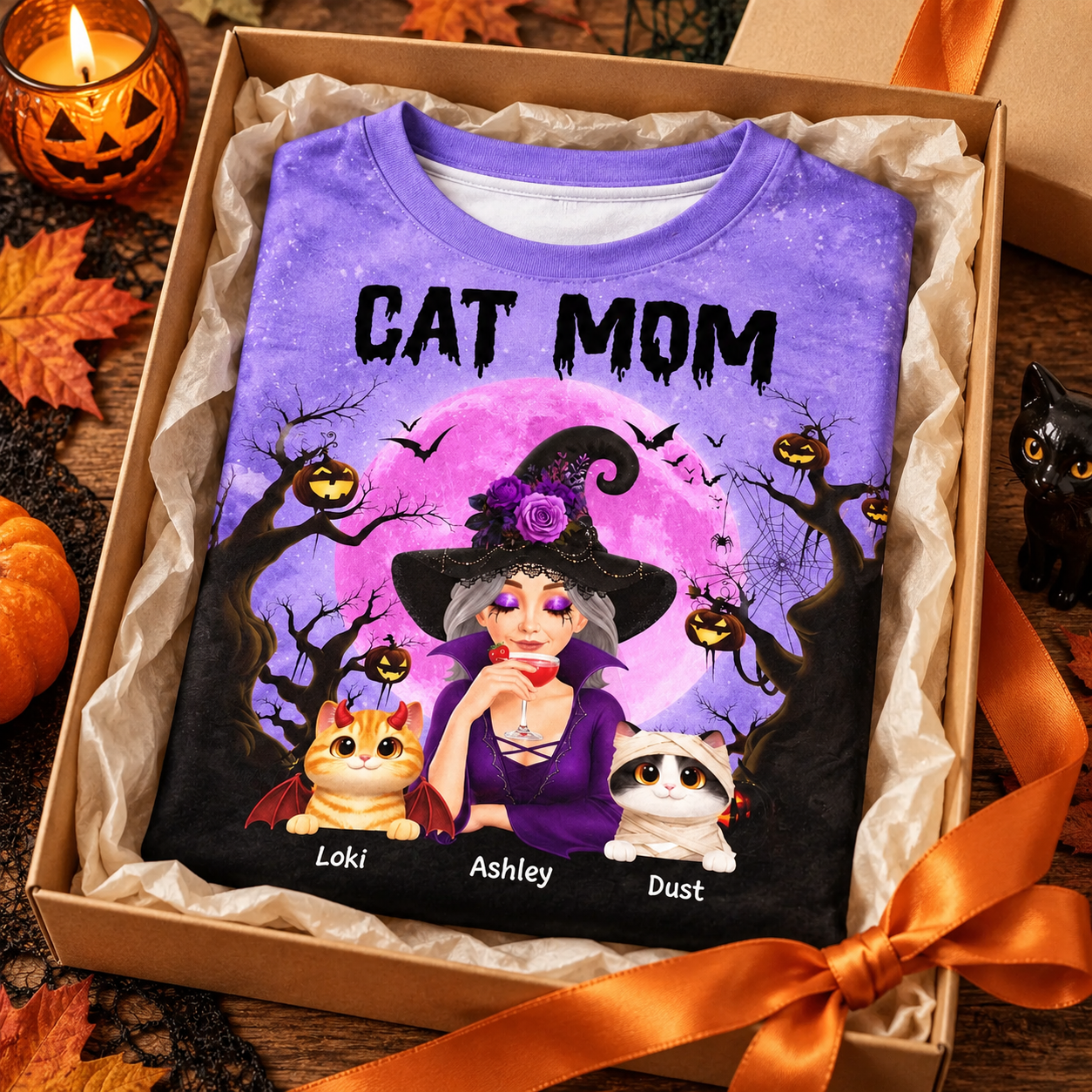 Halloween cat mom witch all-over print t-shirt folded in a kraft gift box with orange ribbon