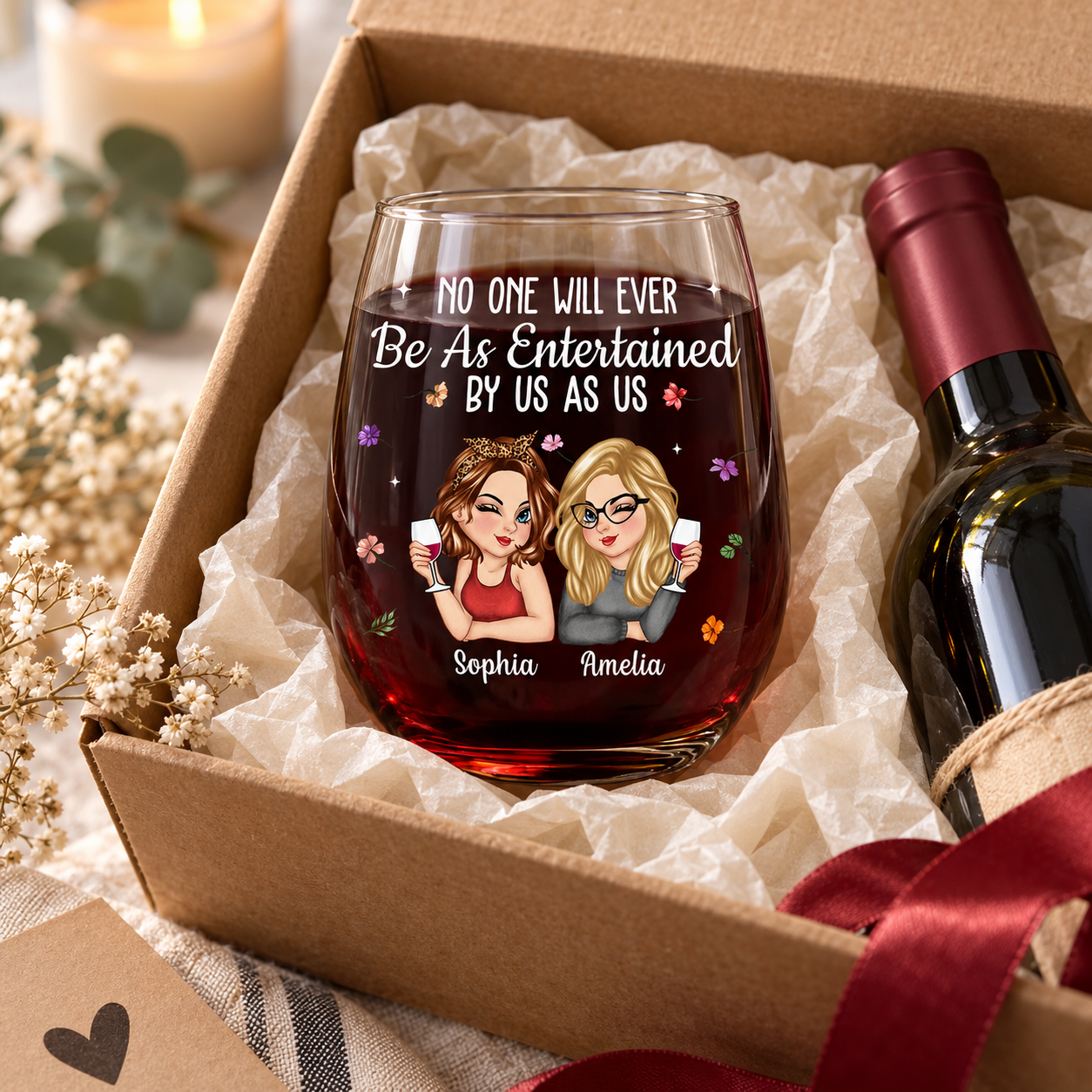 Custom bestie stemless wine glass in a kraft gift box with tissue paper beside a wine bottle