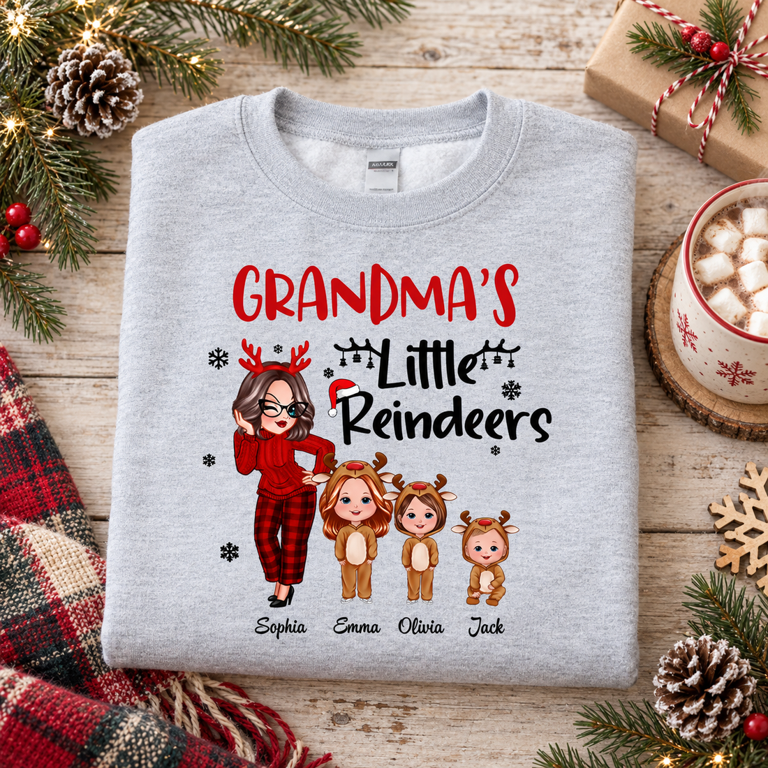 Personalized Grandma's Little Reindeers Christmas sweatshirt flat lay with cocoa and pine branches