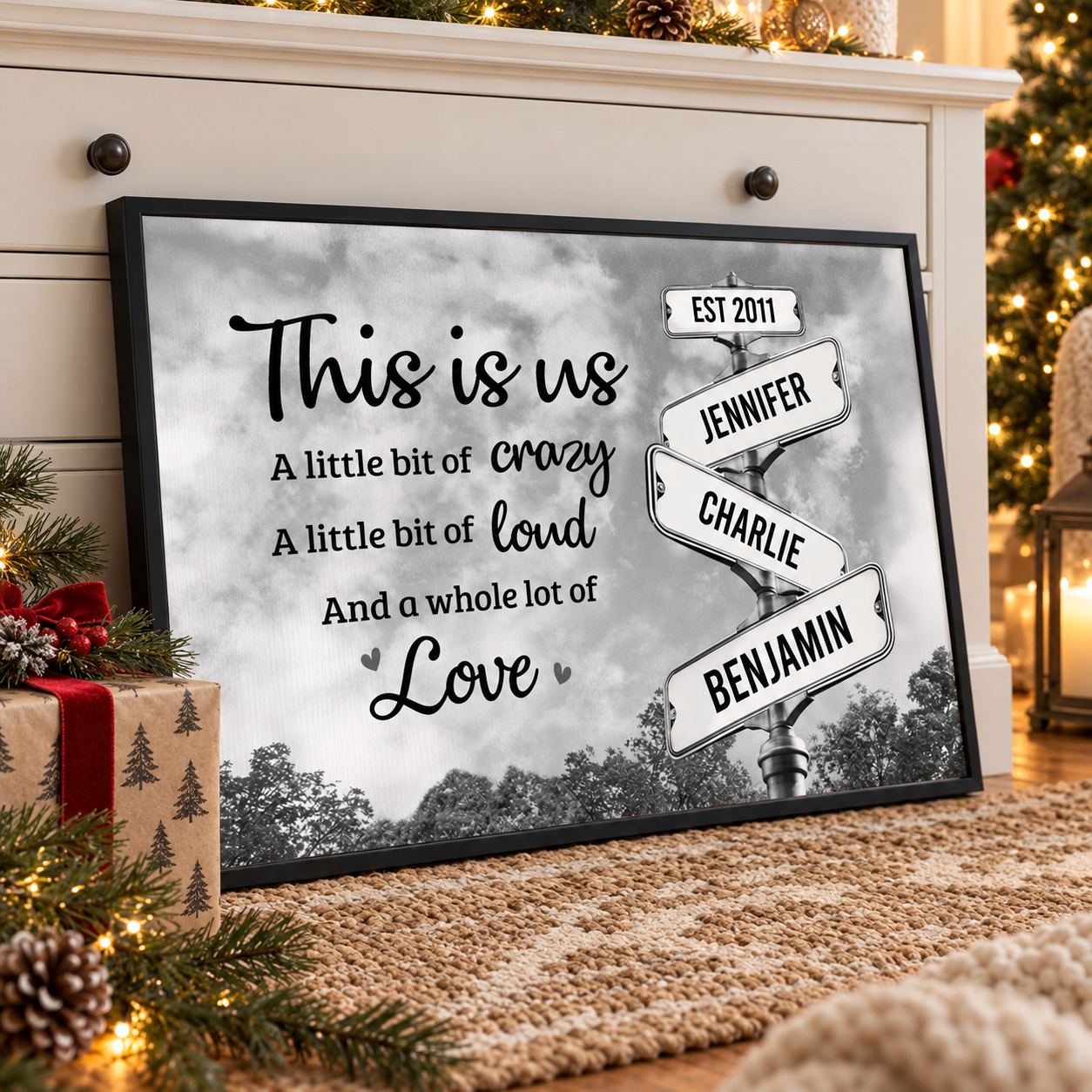 Personalized This Is Us family signpost poster on a dresser beside a Christmas gift and pine branches
