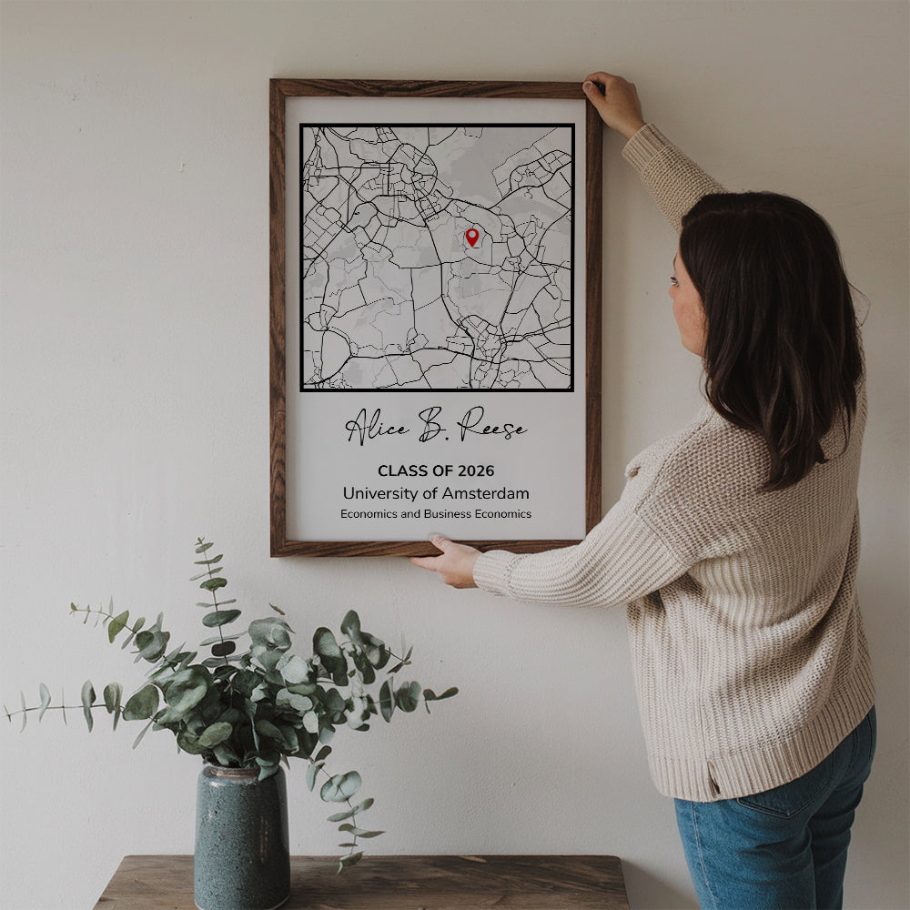 Personalized Graduation Gift Map Print poster, a woman hanging the framed print on a wall