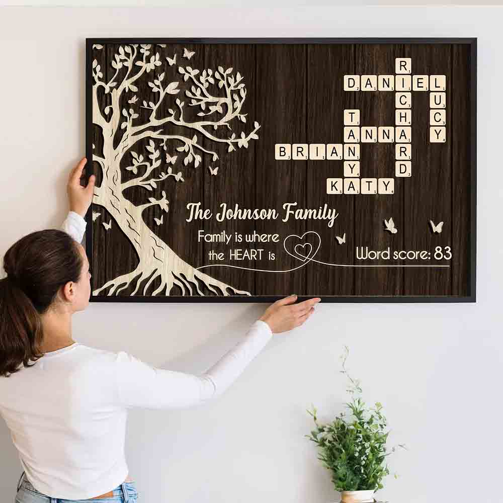 Personalized Family is Where the Heart is, Crossword Tree of Life canvas print, a woman hanging the framed print on a wall