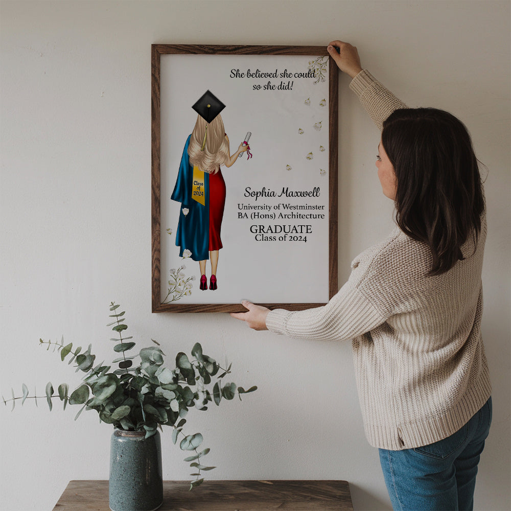 Personalized She Believed She Could So She Did poster, a woman hanging the framed print on a wall