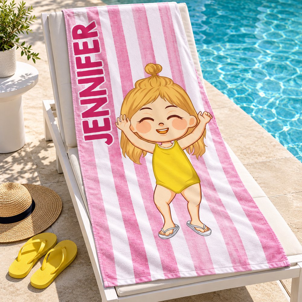 Personalized pink striped kids beach towel draped over a poolside lounge chair in bright sunlight