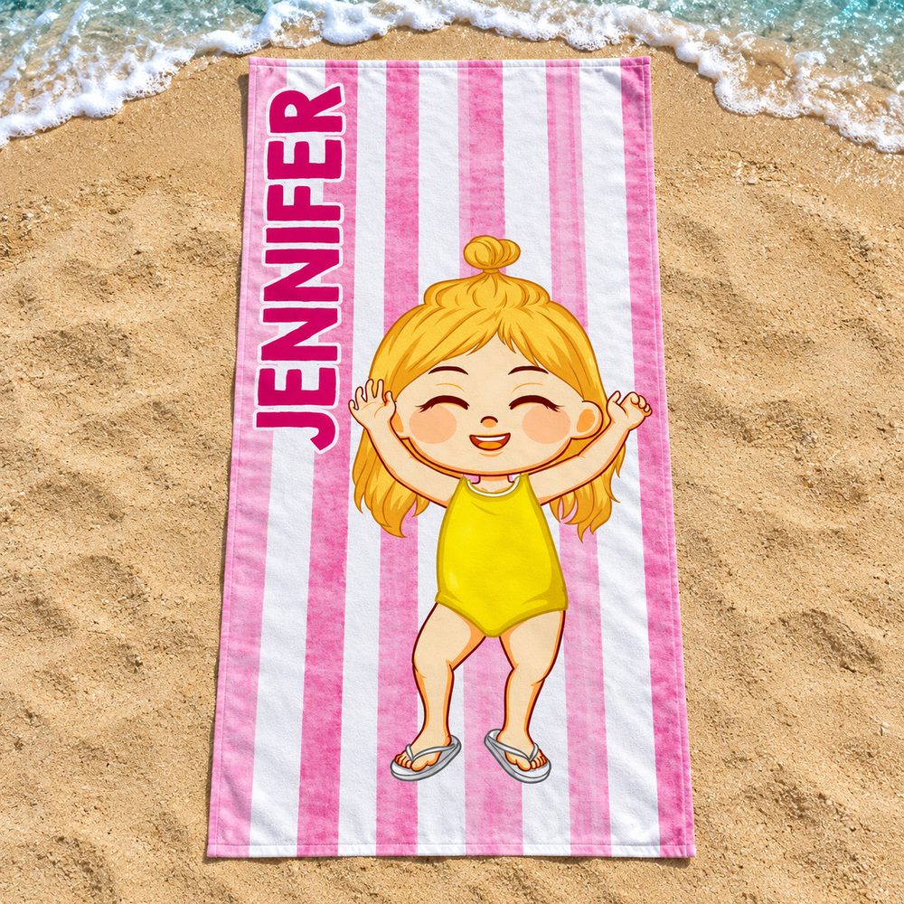 Personalized JENNIFER striped kids beach towel spread flat on golden sand by the ocean