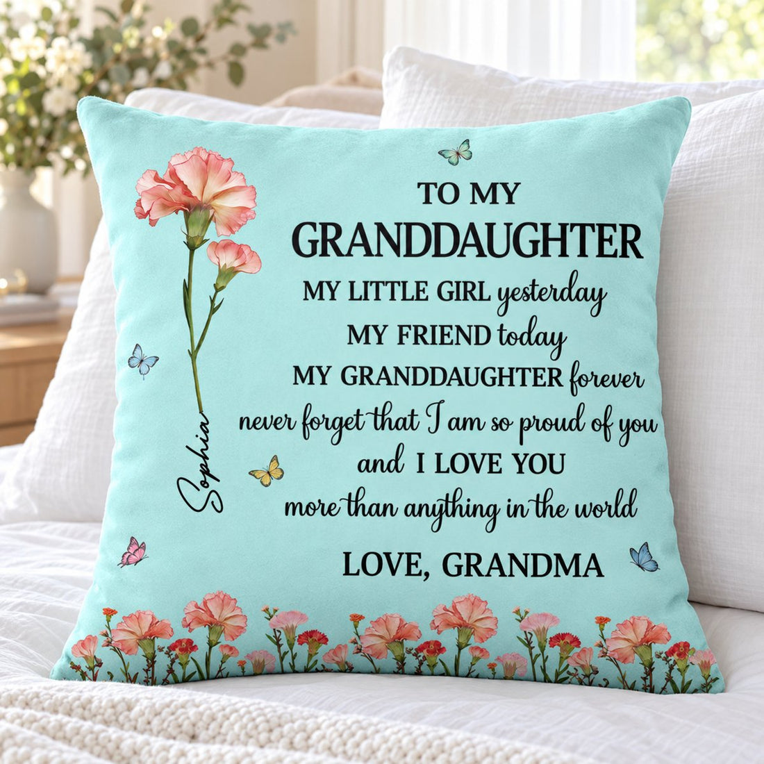 Custom birth flower granddaughter throw pillow displayed on a bright cozy bed