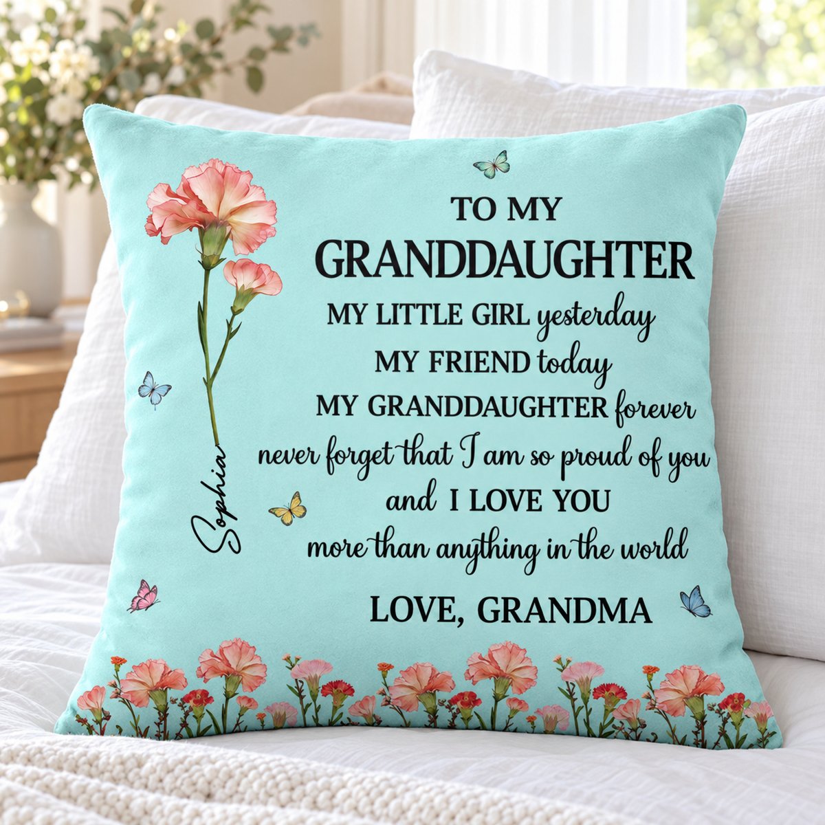 Custom birth flower granddaughter throw pillow displayed on a bright cozy bed