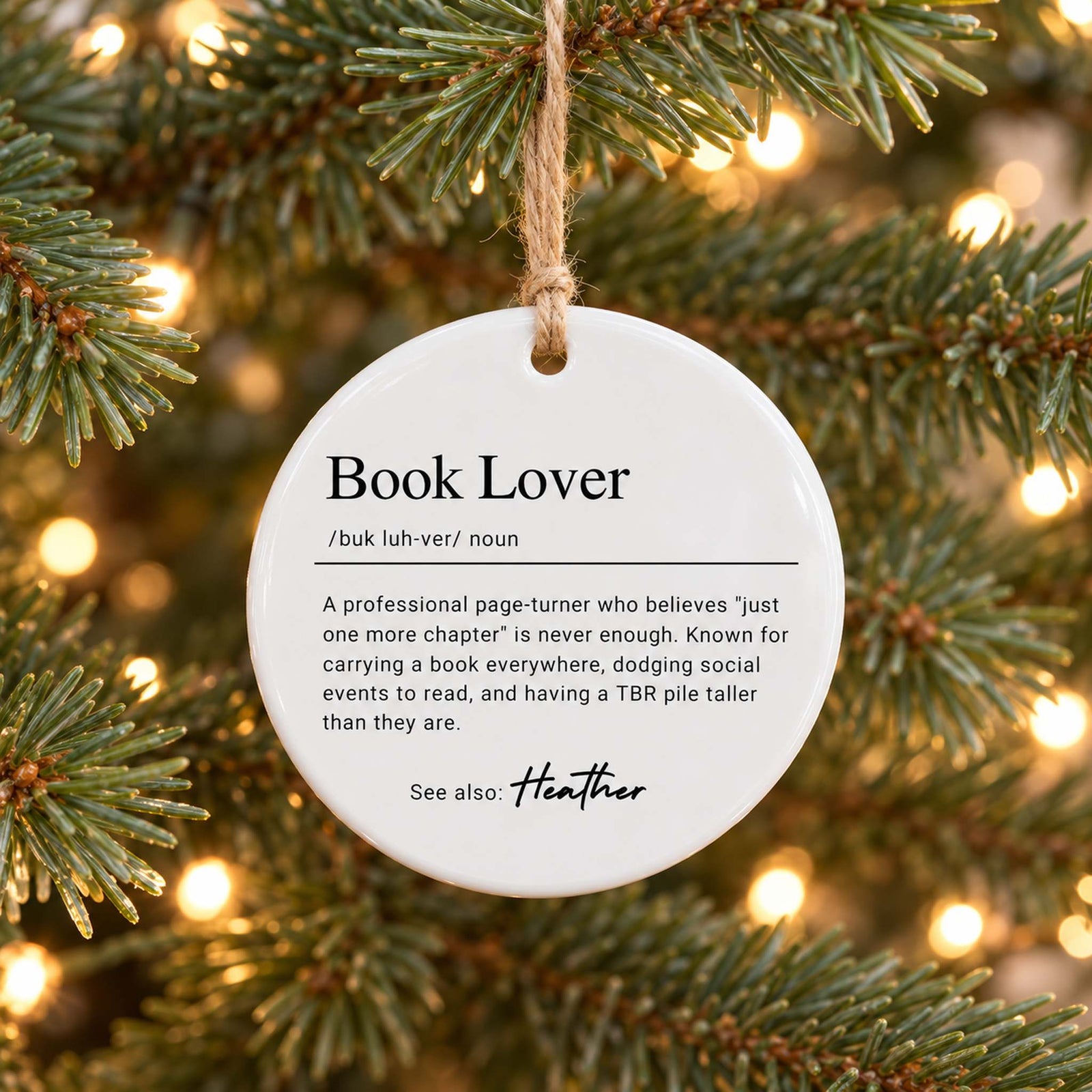 Book Lover Definition personalized circle ceramic ornament hanging on a Christmas tree branch
