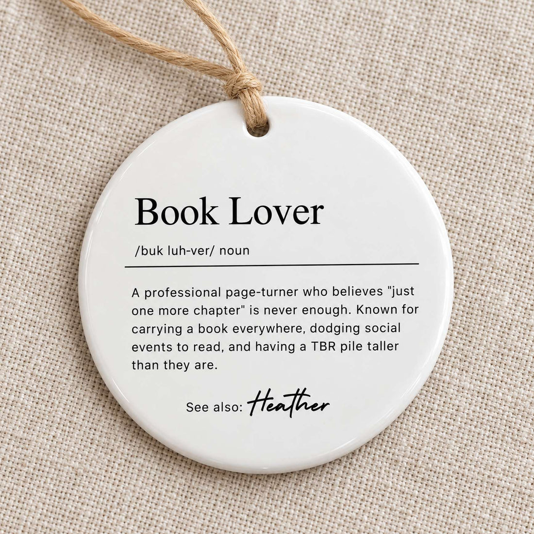 Macro closeup of the glossy ceramic finish and printed definition text on the Book Lover ornament