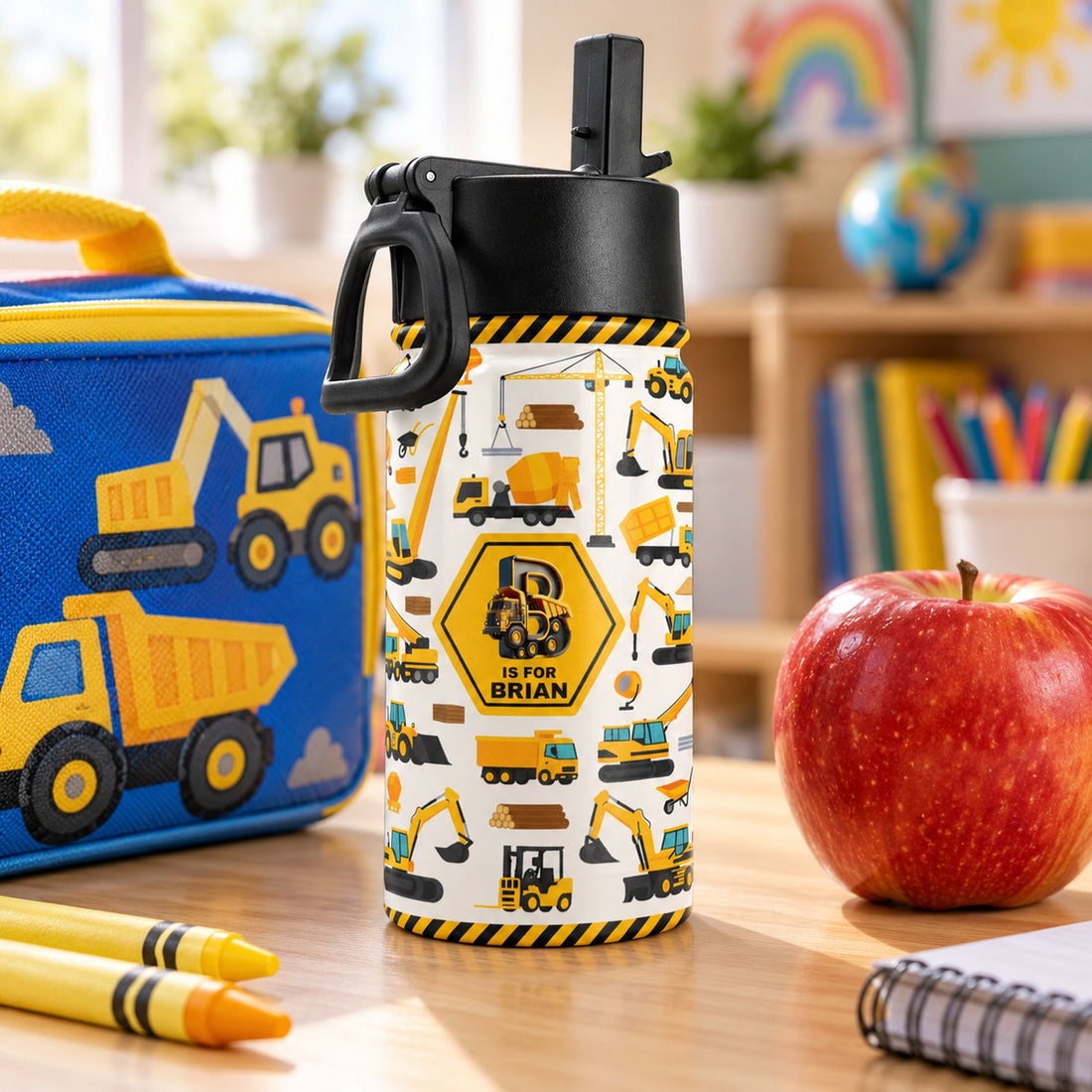 12oz personalized construction kids water bottle next to a lunchbox and apple for size comparison