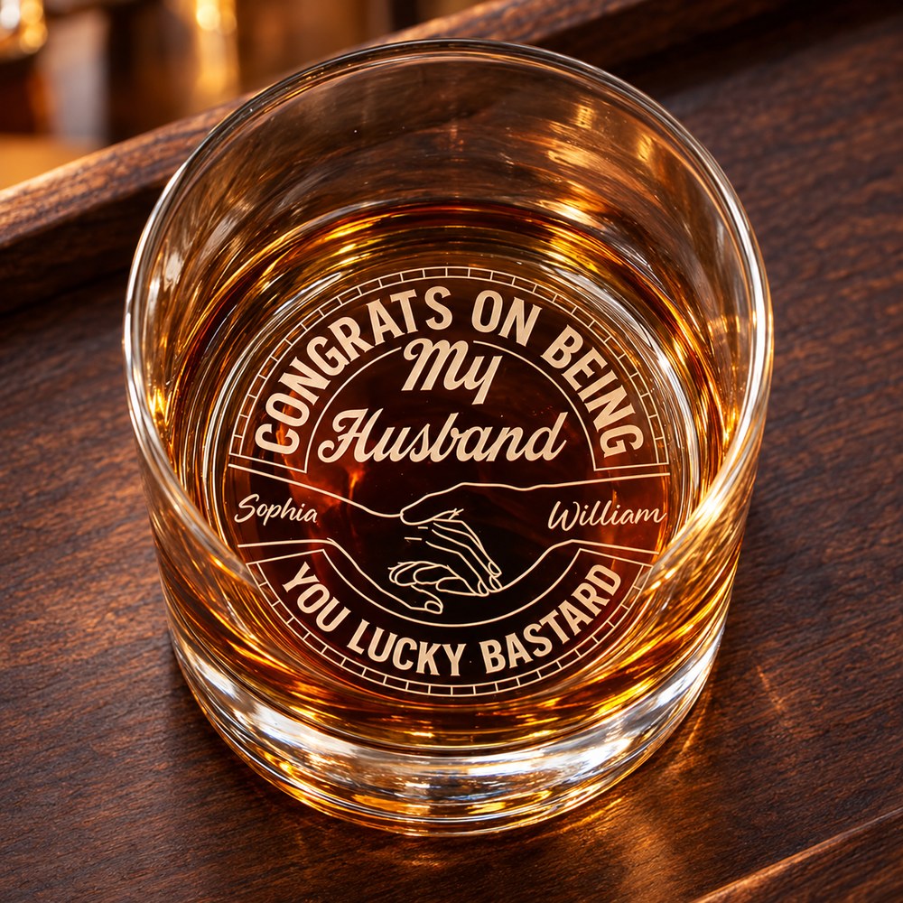 Engraved whiskey glass with Sophia and William names on a wooden bar tray showing bottom laser etching