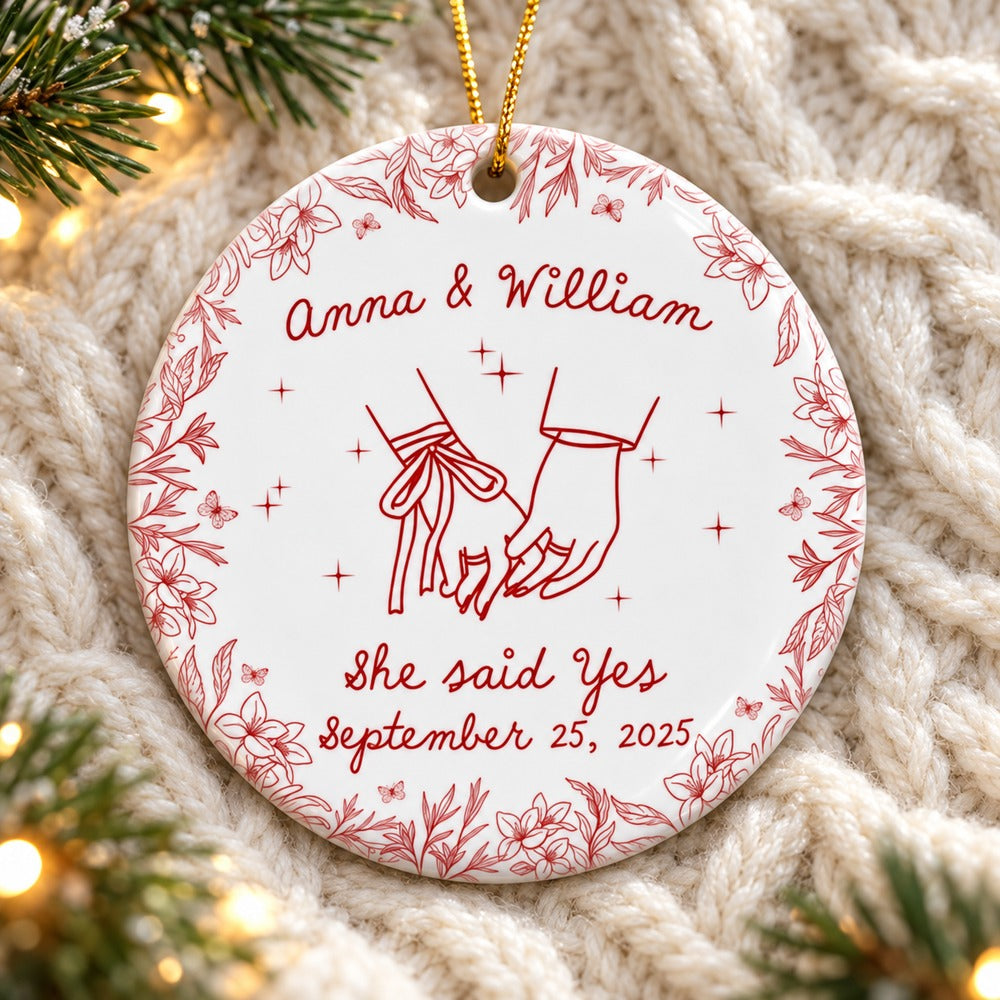 Personalized couples circle ceramic ornament lying on cozy cream knit blanket with pine sprigs