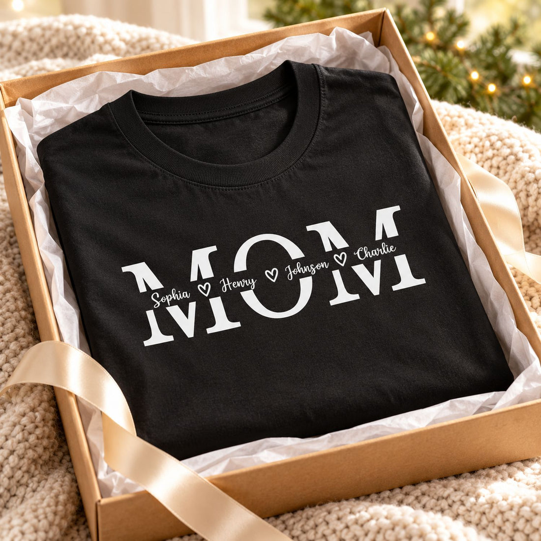 Folded Custom Name Mom T Shirt inside a holiday gift box with ribbon and tissue paper