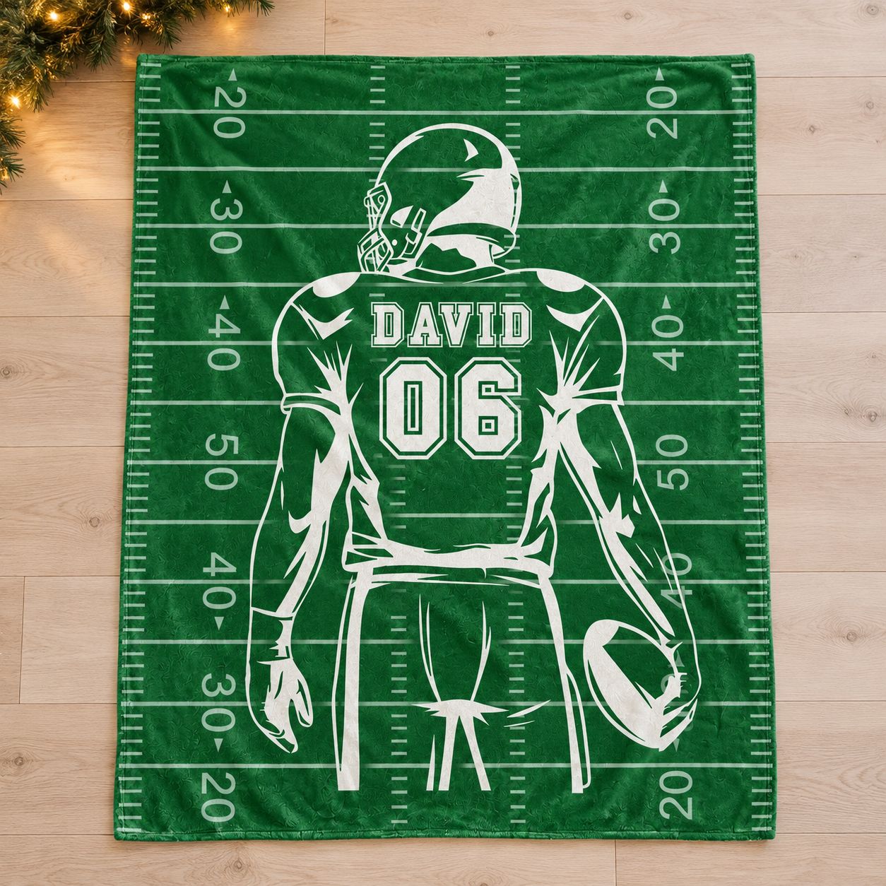Custom Name and Number Football Blanket DAVID 06 spread flat on floor with holiday greenery