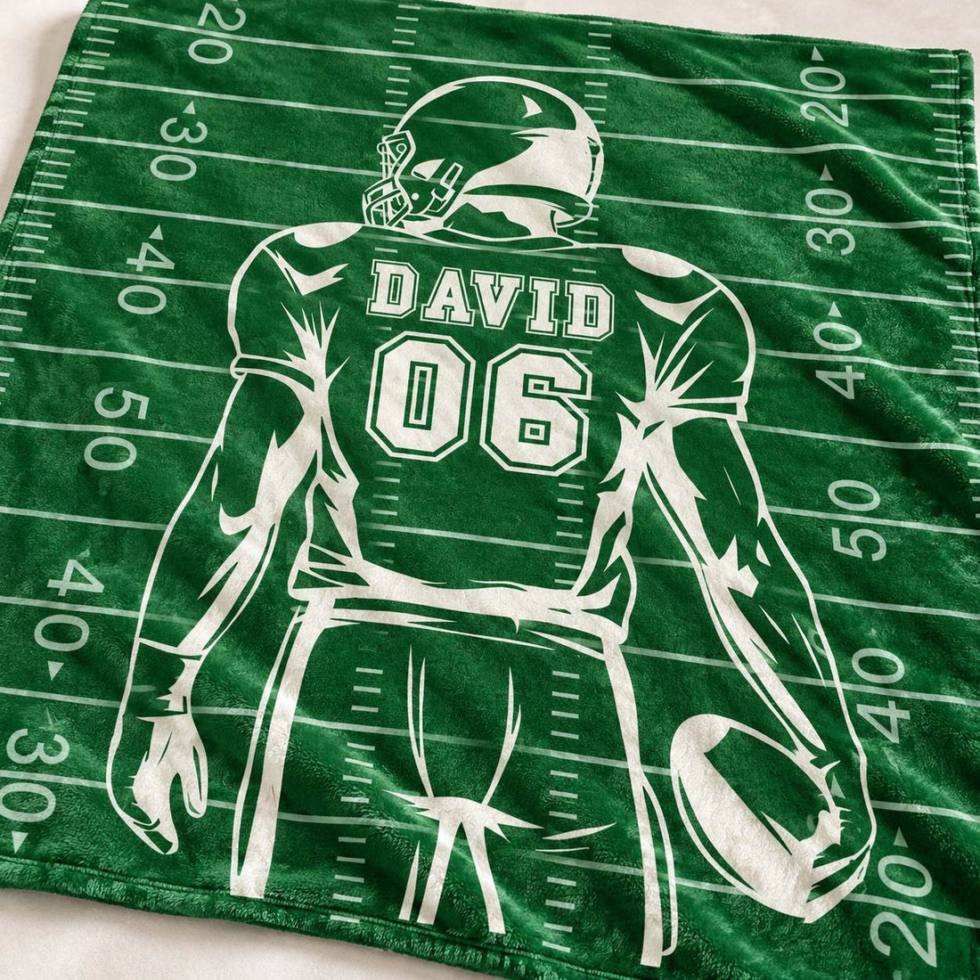 Close up detail of plush fleece texture and custom printed name DAVID 06 on football blanket