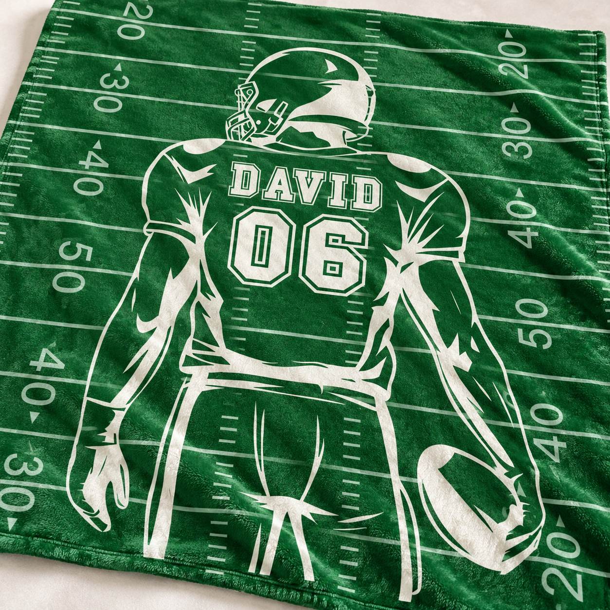 Close up detail of plush fleece texture and custom printed name DAVID 06 on football blanket