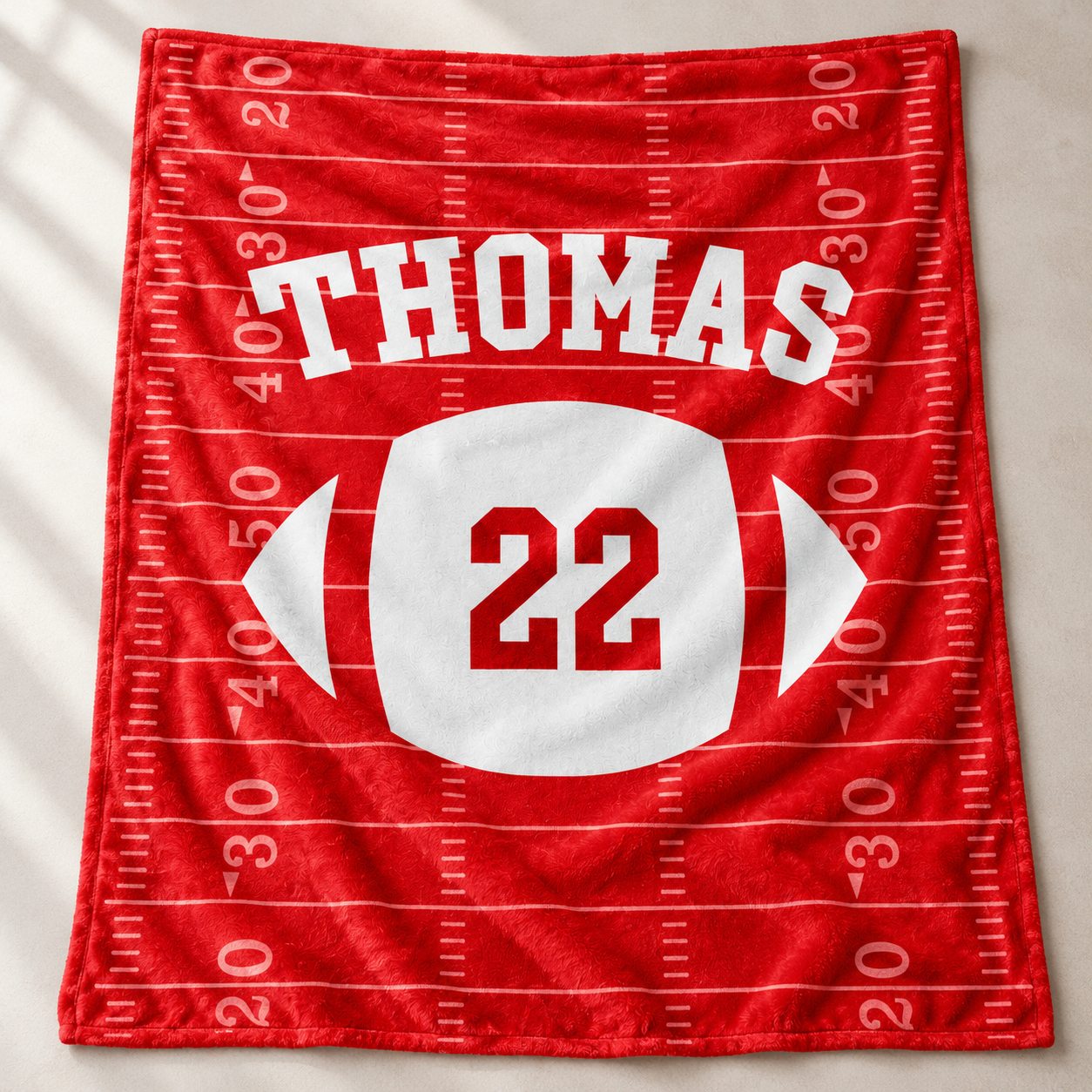 Close-up detail of soft plush fleece texture and vibrant print on custom football blanket