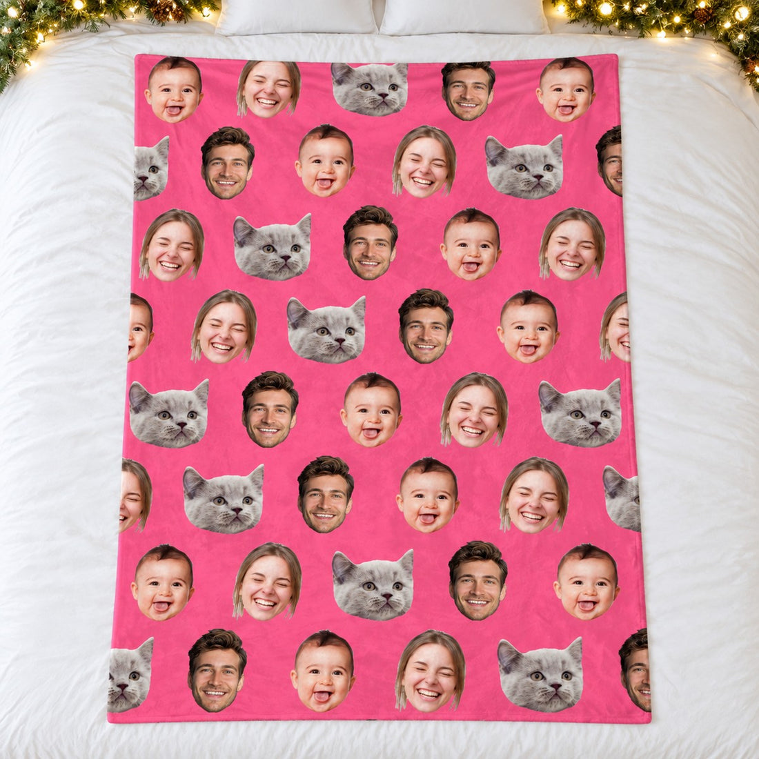 Custom photo family blanket with pink background and family faces spread flat on bed with holiday greenery