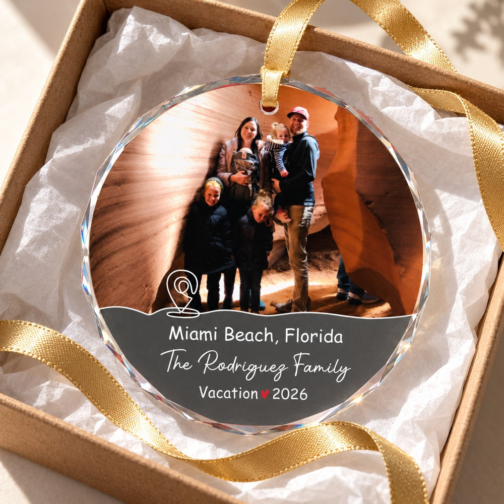 Personalized family vacation glass ornament nestled in an open gift box with tissue paper