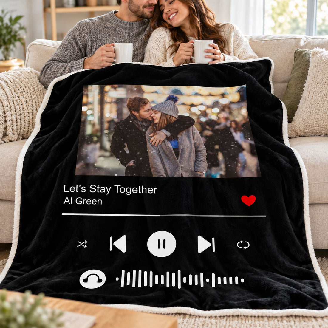 Husband and wife snuggling under personalized photo music player blanket on a bright couch