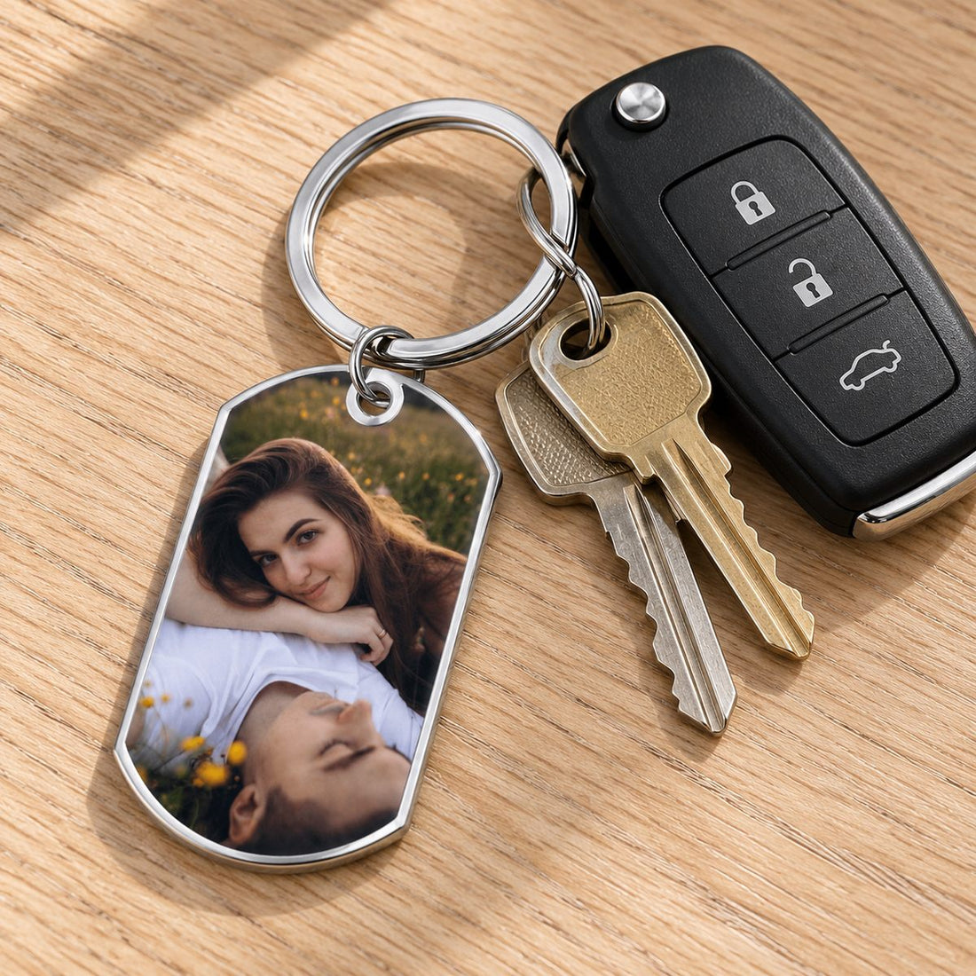 Custom stainless steel photo keychain attached to house and car keys on a wooden table
