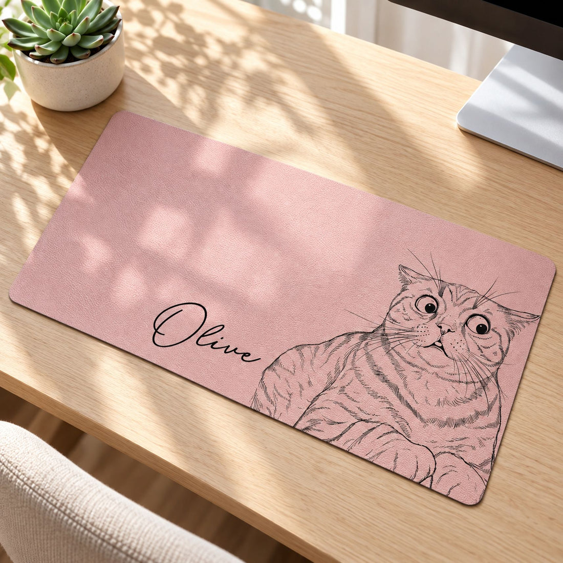 Close-up detail of pebbled texture and black line art cat portrait on personalized desk mat