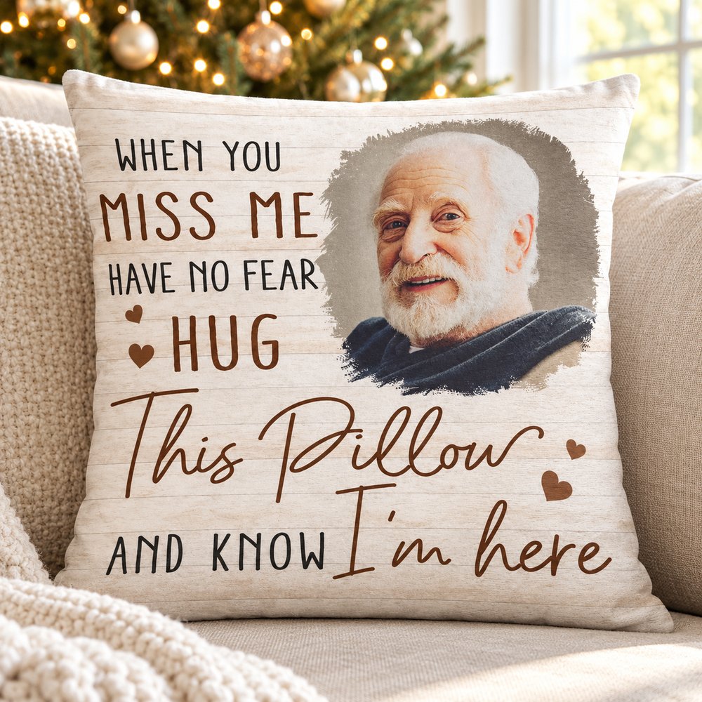 Custom photo memorial pillow on a cozy sofa with a Christmas tree softly glowing in the background