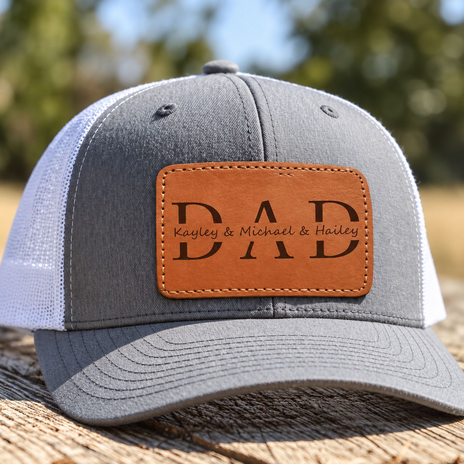 Close-up of stitched brown leather patch with engraved DAD and kids names