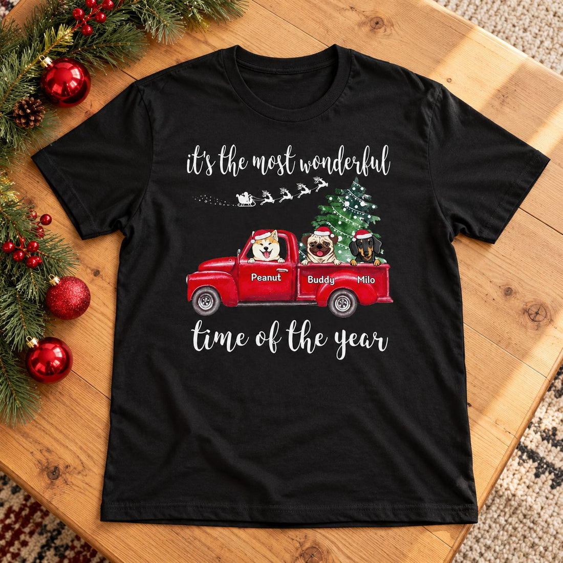 Personalized Christmas dog t-shirt laid flat with pine garland and ornaments