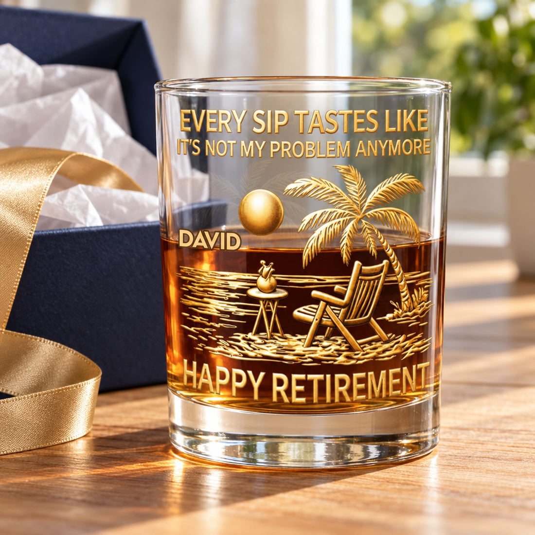 Personalized retirement whiskey glass next to open gift box with ribbon