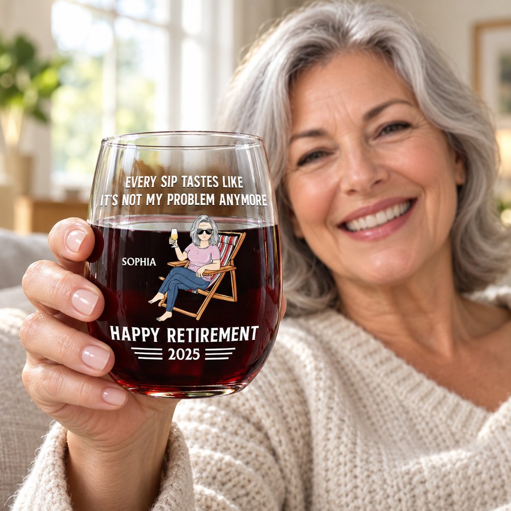 Retired woman holding personalized 15oz stemless retirement wine glass in a bright cozy living room