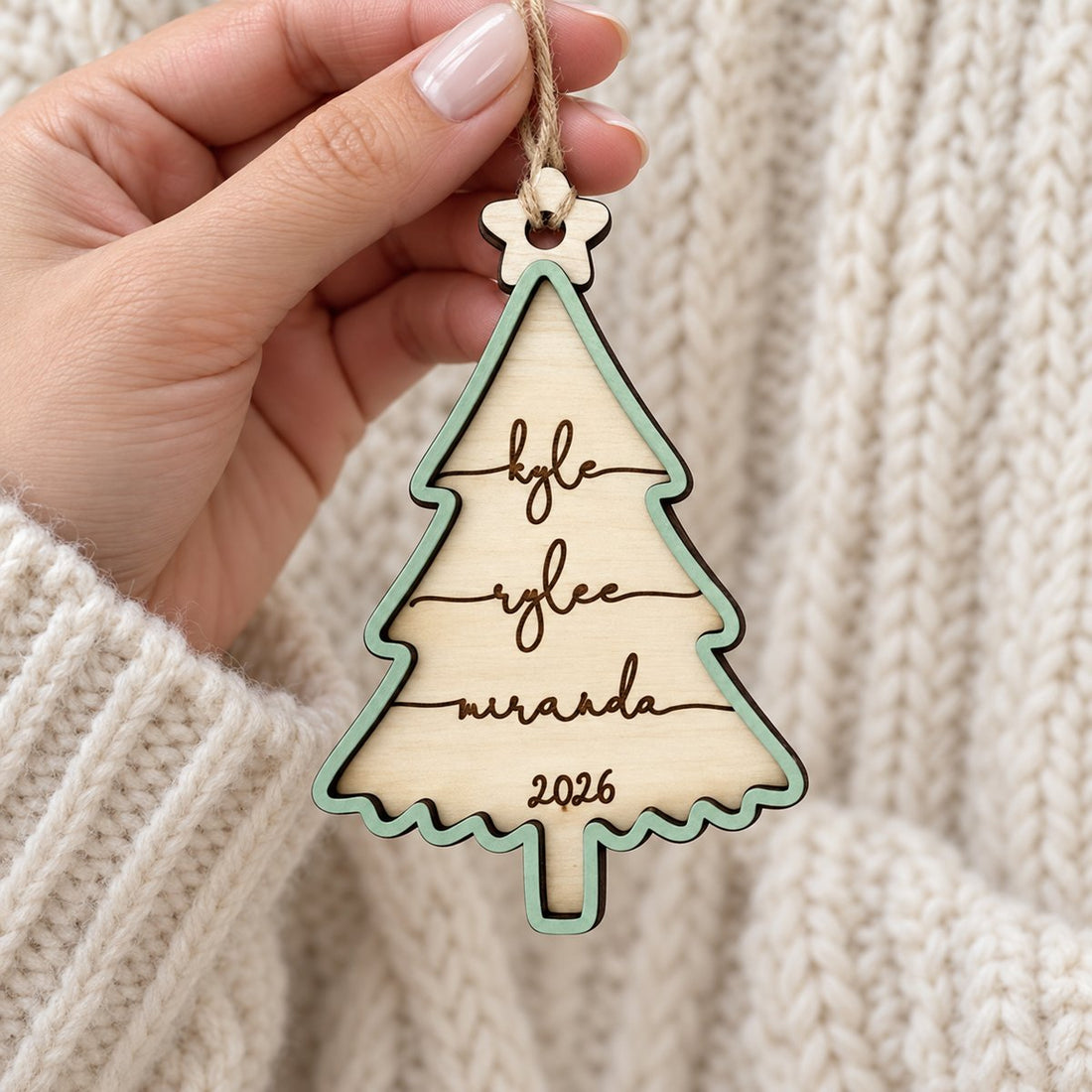 Hand holding personalized 2-layer wooden family Christmas tree ornament to show real size