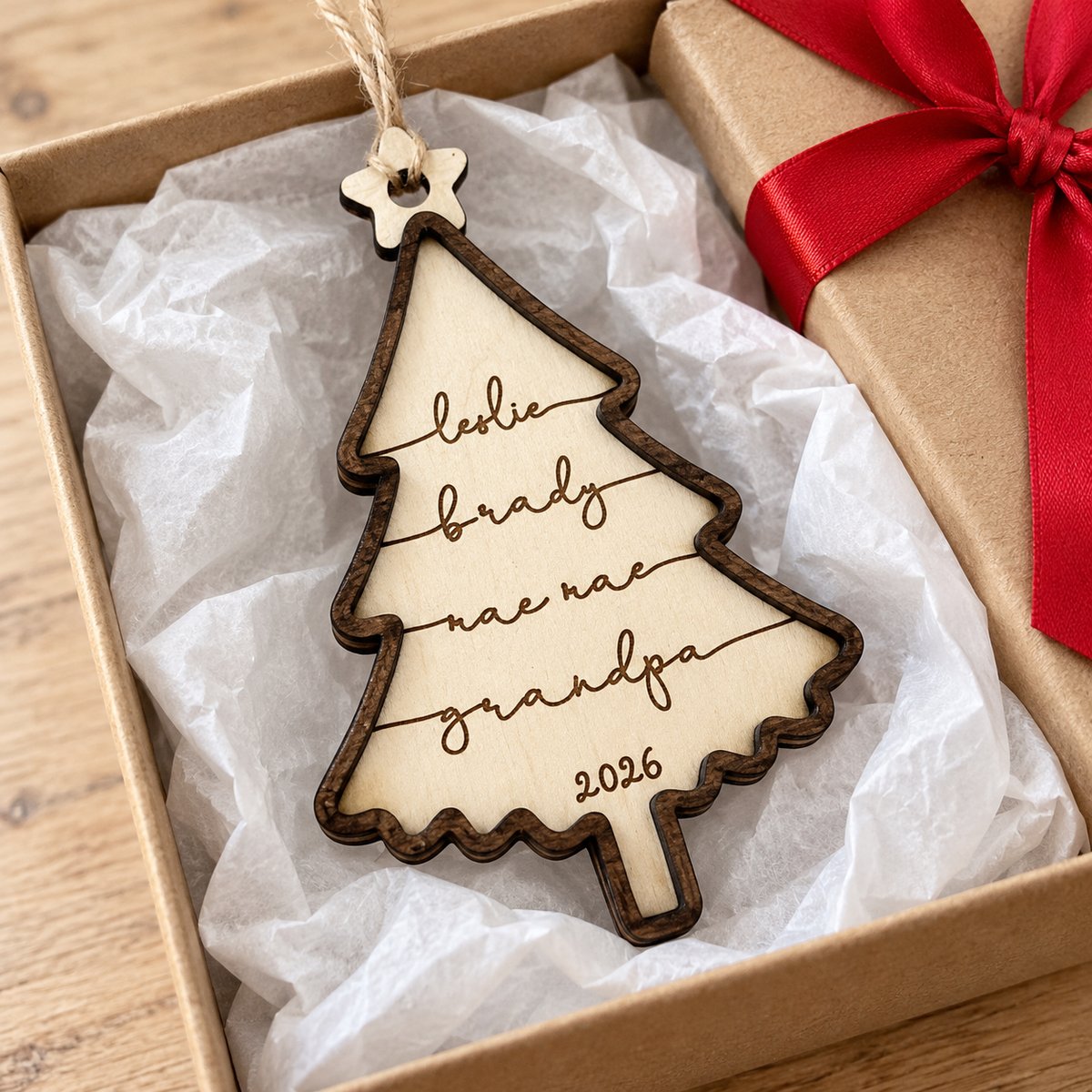 Personalized family Christmas tree wooden ornament in an open holiday gift box with ribbon