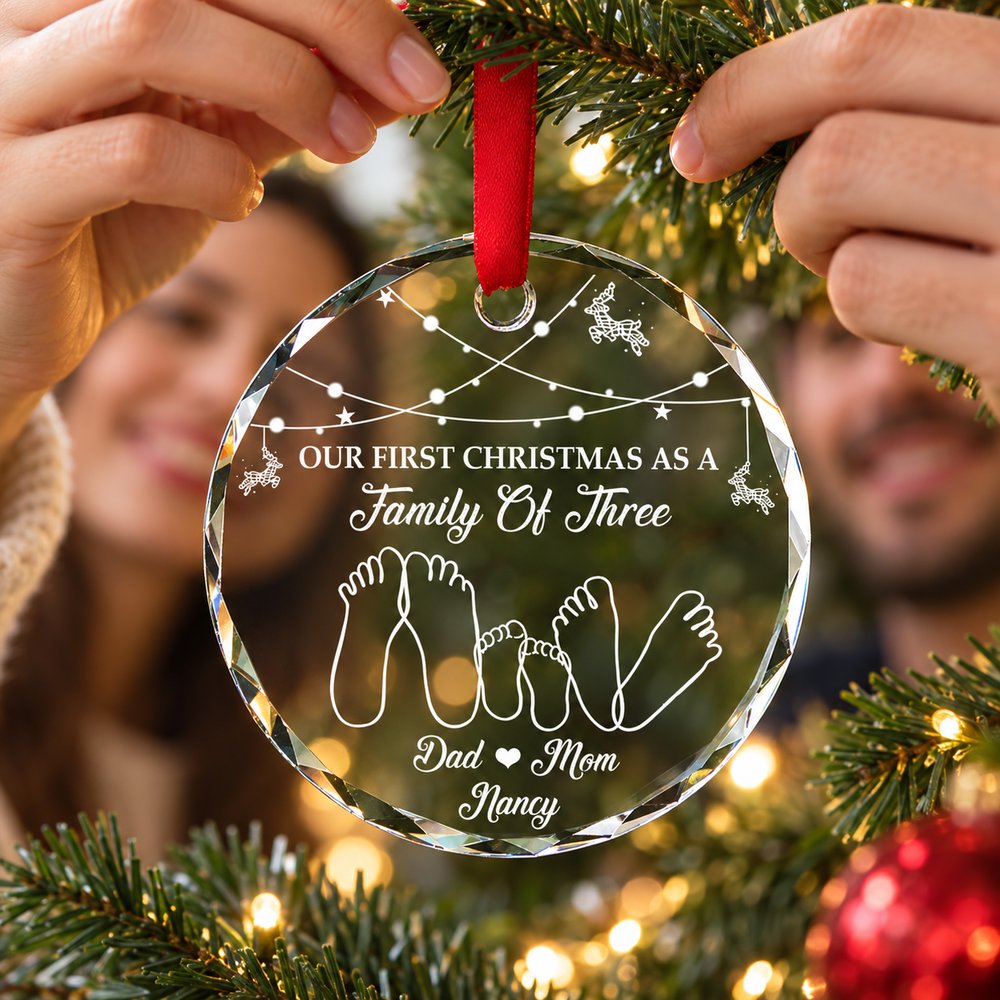 New parents hanging First Christmas As A Family Of Three circle glass ornament on tree