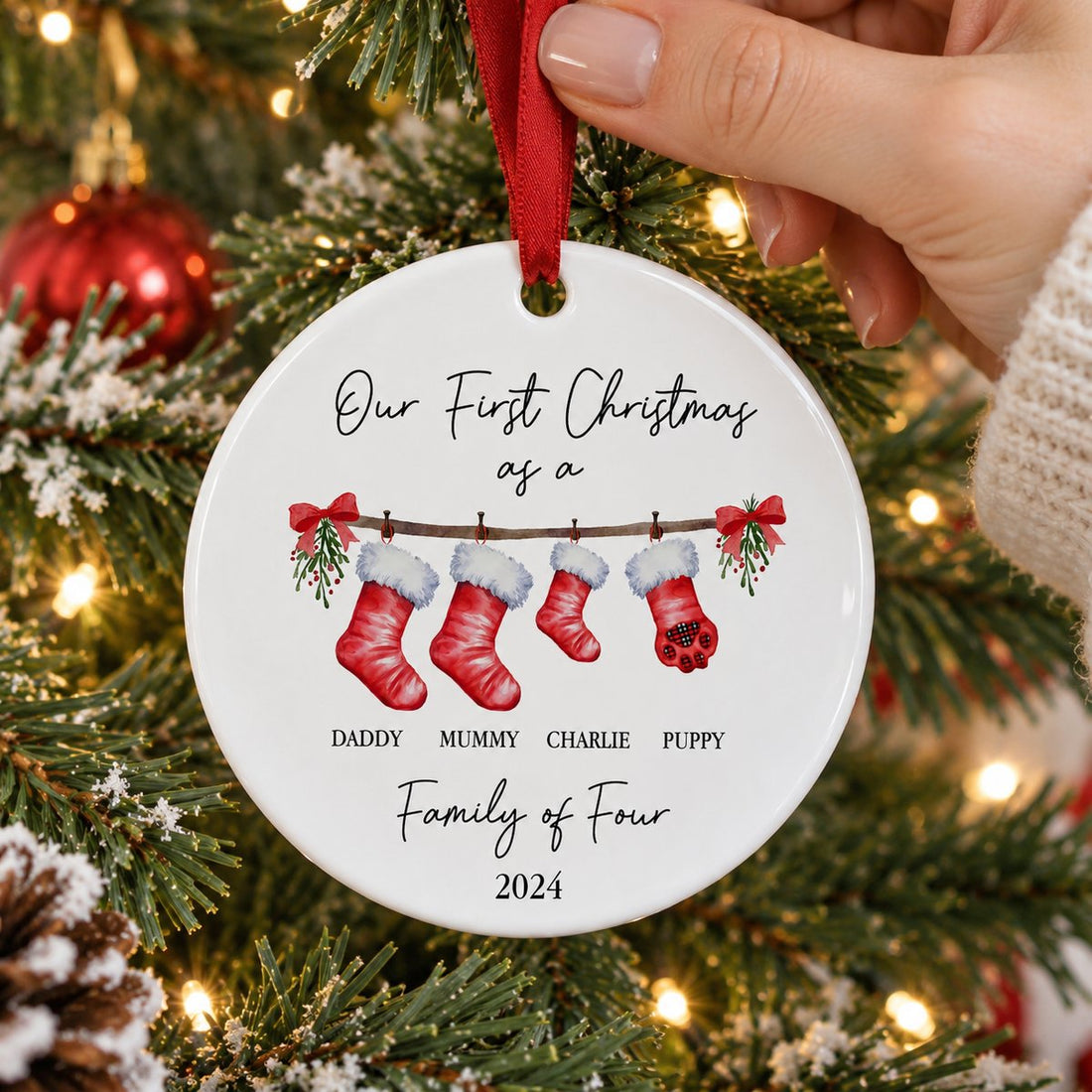 First Christmas as a Family With Pet ceramic ornament being hung on a Christmas tree branch