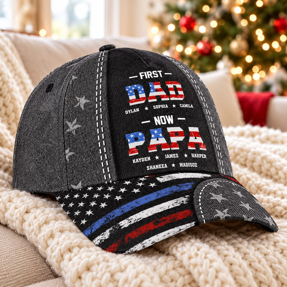 Personalized First Dad Now Papa cap on a cozy sofa near a Christmas tree