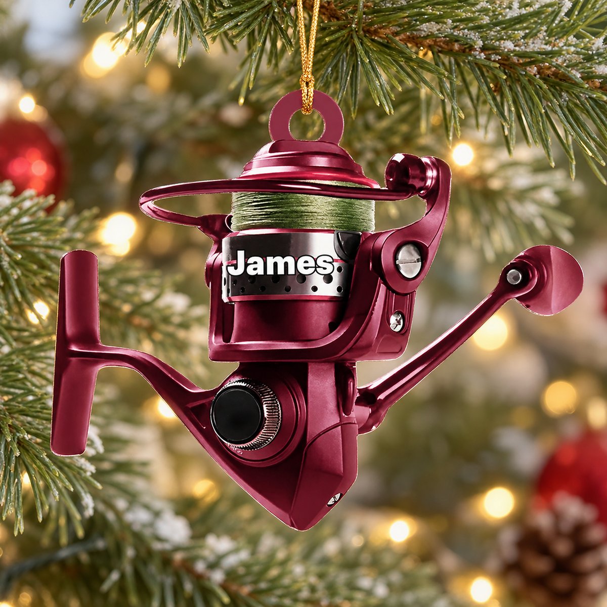 Personalized burgundy fishing reel acrylic Christmas ornament hanging on a pine tree branch