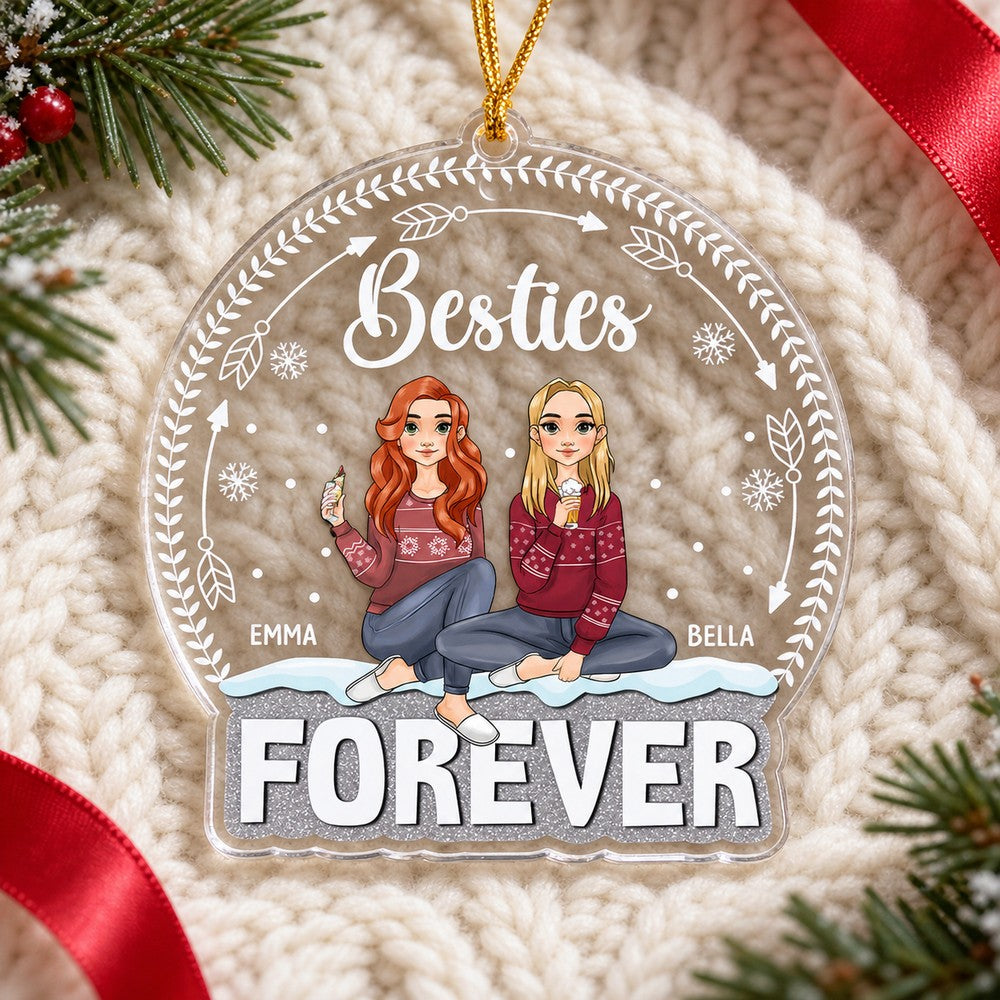 Custom shaped Besties Forever acrylic ornament lying flat on a cream cable-knit blanket with pine greenery