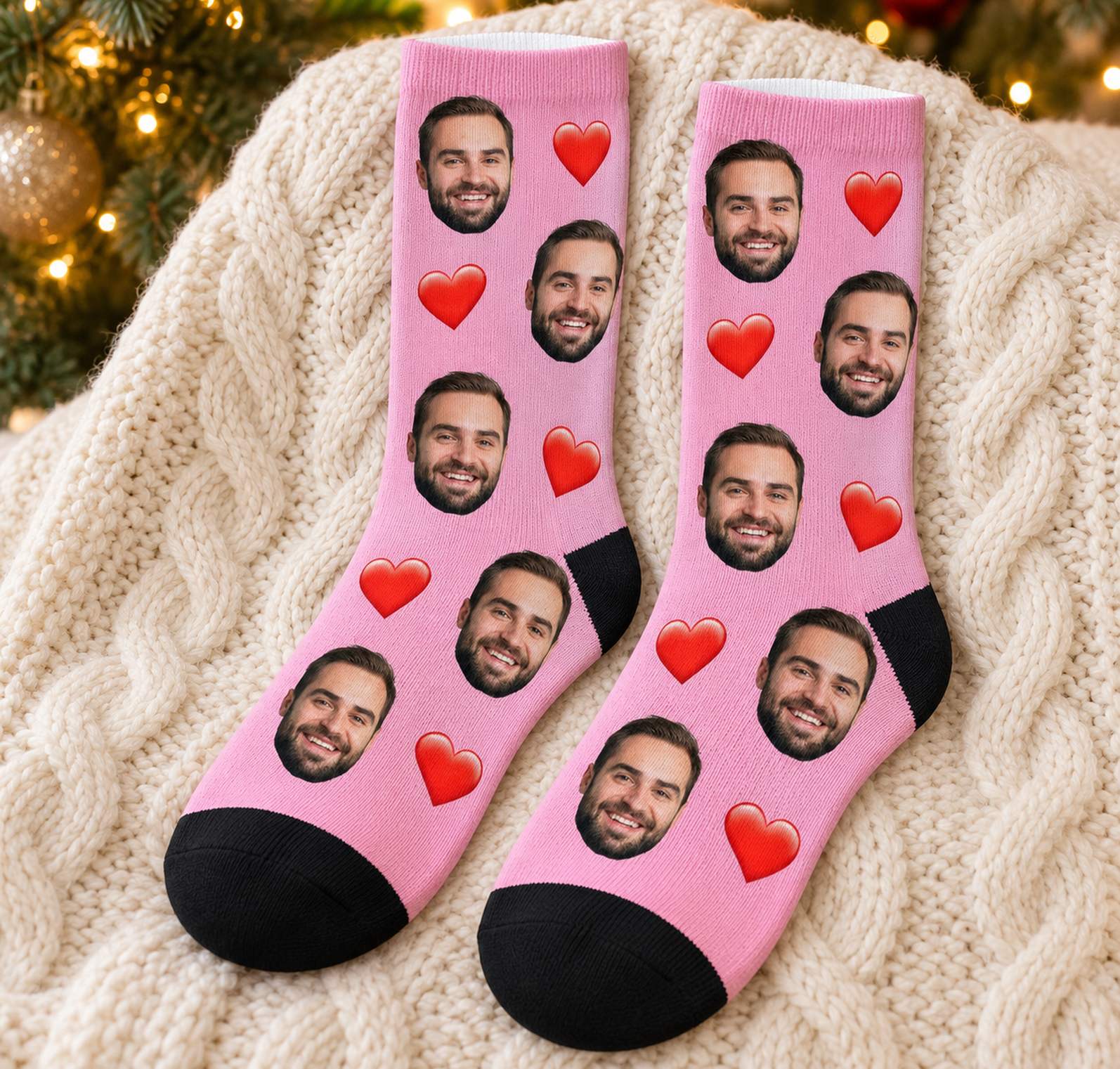 Funny custom face crew socks in pink with red hearts laid flat near Christmas decor