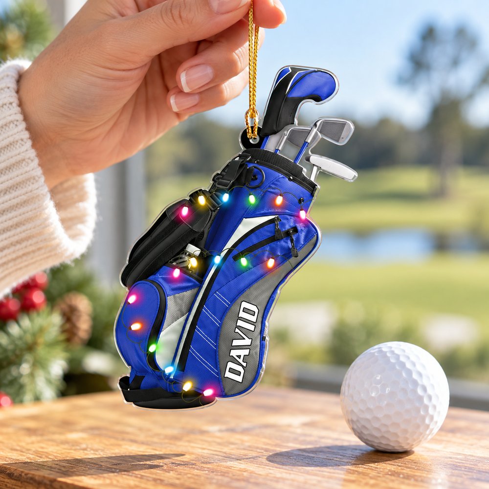 Hand holding the 3.5 inch personalized golf bag acrylic ornament next to a golf ball for scale
